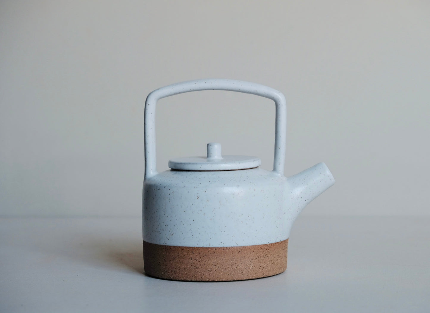 White teapot with raw clay base