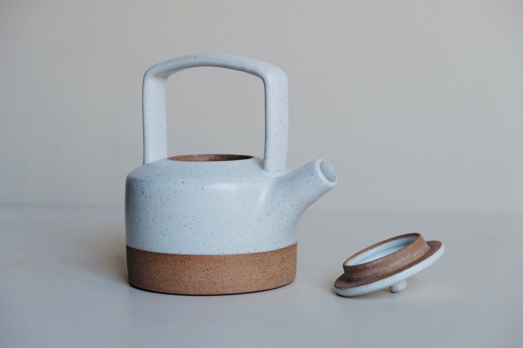 White teapot made of stoneware with the lid off
