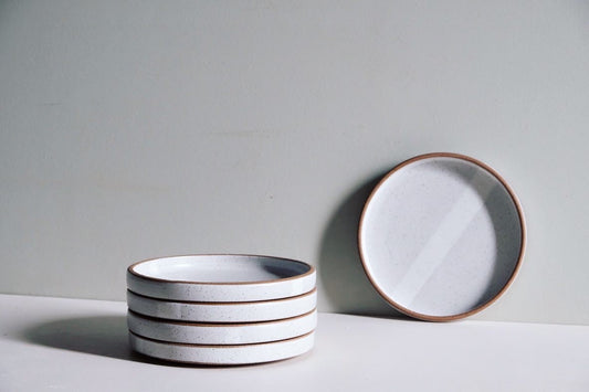 A smaller-sized plate with 1/2 inch vertical walls that's fully dipped in white glaze on either side, creating a line down the middle. The rim is wiped clean.