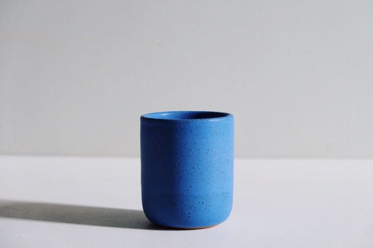 A handmade cup fully dipped in cerulean blue glaze.