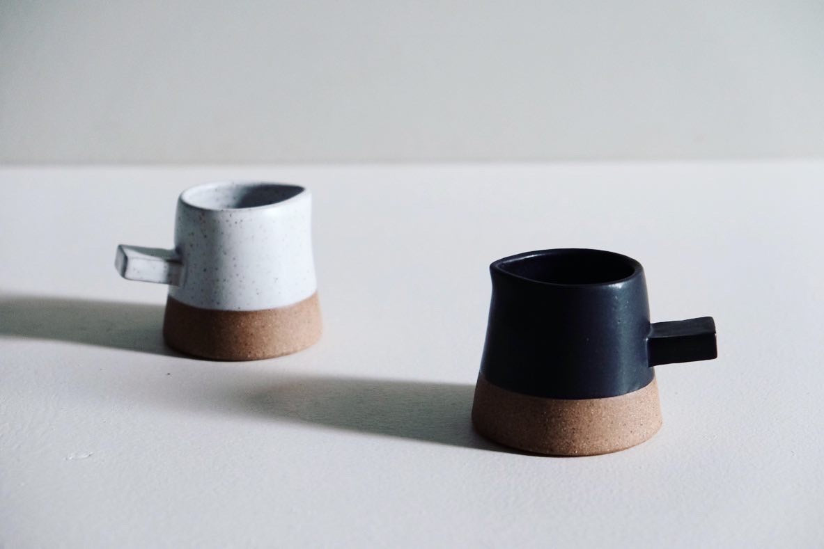 A mini little creamer with angular features dipped in 3/4 black satin glaze.
